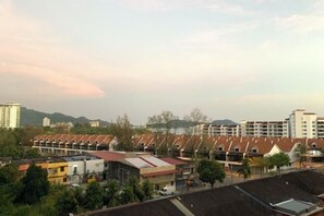 A residential area with multiple-story buildings, some with red roofs, and a clear sky. - Century Suria Apartment Langkawi by Zervin (Langkawi)