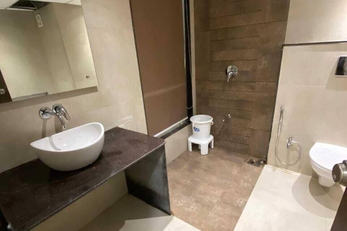 A modern bathroom with a large sink, a toilet, and a shower area.