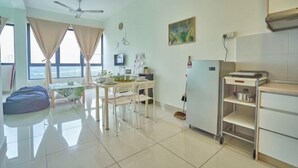 A modern living room with a dining area, a ceiling fan, a kitchen area with a cart, and large windows with curtains.