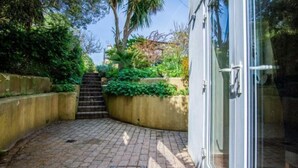 Un patio empedrado con una escalera de piedra que lleva a una puerta.