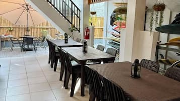 A dining area with a staircase, outdoor seating, and a view of the garden.