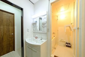A bathroom with a white sink, mirror, and shower. - Akisapo Stay Motohasunuma (Tokyo)