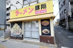 A restaurant with a yellow awning and signage in both Japanese and English. - Akisapo Stay Motohasunuma (Tokyo)