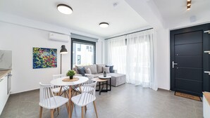 Ein modernes Wohnzimmer mit Essbereich, ausgestattet mit einer Sofagarnitur, einem Couchtisch und einem Esstisch mit Stühlen.