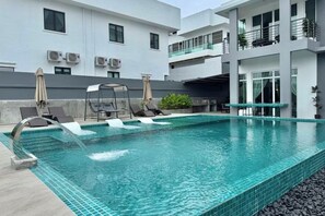 A modern pool area with clear blue water, lounge chairs, and a water feature. - Private Pool Retreat, 6BR Langkawi Villa by Zervin (Langkawi)