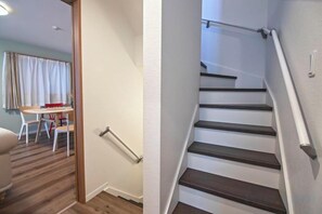 A staircase with a handrail, a dining area with a table and chairs, and a wooden floor. - Tabitime Teradacho - 5 min to JR station~grand new house~max 8ppl (Osaka)