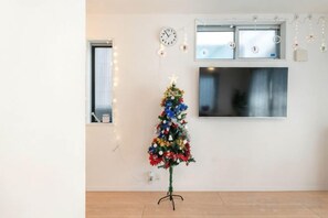 Una habitación con un árbol de Navidad, un reloj y una ventana.