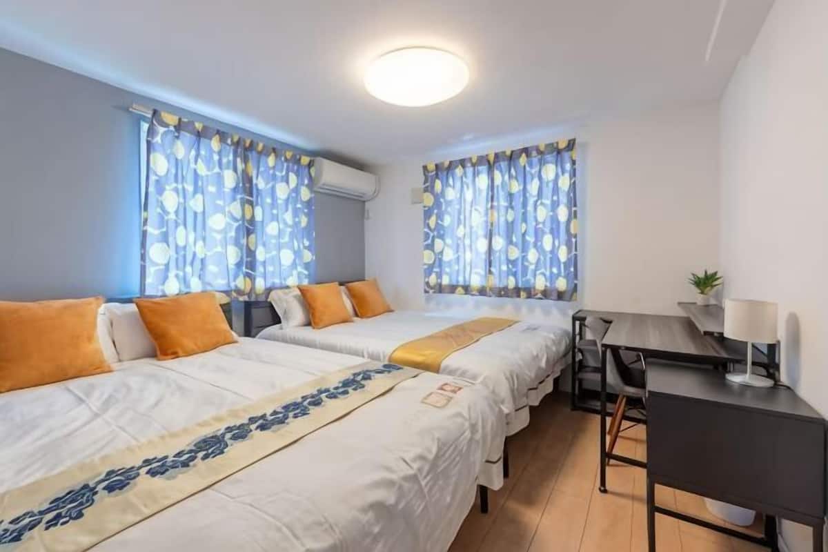Une chambre avec deux lits, un bureau et une chaise.