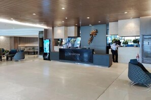 A reception area with a reception desk, seating, and a modern interior design. - Lascianos SMDC Shore Residences by RedDoorz (Pasay)