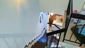 Eine Treppe mit Geländer und einer runden Wandleuchte.