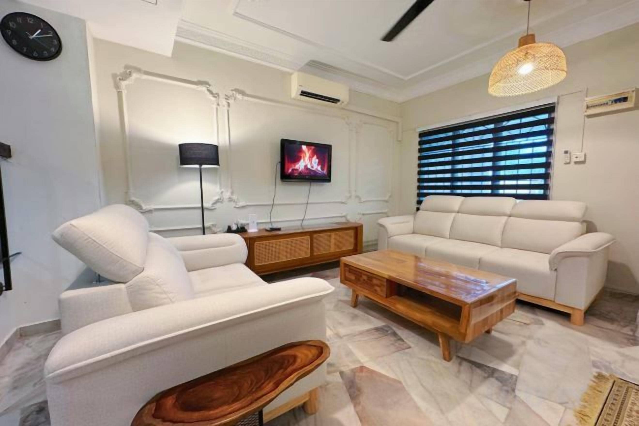 A modern living room with a sofa, armchairs, a coffee table, and a TV.