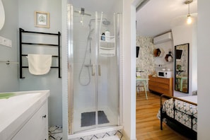 Un bagno moderno con doccia vetrata, lavandino bianco e mobile bagno in legno.