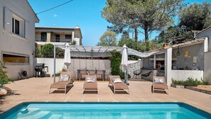 A swimming pool with lounge chairs, a pergola, and a patio area. - 'Jungle' Guest Room with Shared Pool, Wi-Fi, and Air Conditioning (Saint-Raphaël)