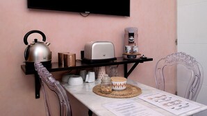 A kitchen with a kettle, toaster, coffee maker, and a TV mounted on the wall. - Pink Suite Guest Room with Shared Pool, Wi-Fi, and Air Conditioning (Saint-Raphaël)