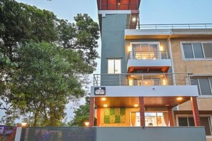 A multi-story building with balconies and a green wall. - HashTag Villa 2BHK in Lonavala (Kune N.m.)