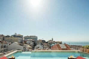 Une piscine sur le toit offrant une vue sur la ville et la mer.