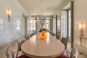 A spacious dining area with a round table, chairs, and a central decorative piece. - Verride Palácio Santa Catarina (Lisbon)