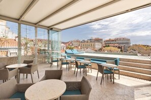A rooftop terrace with outdoor seating, a view of the cityscape, and a covered area. - Verride Palácio Santa Catarina (Lisbon)