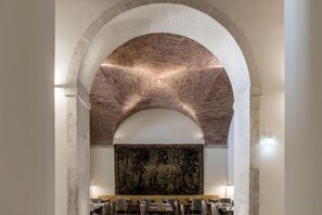 A dining area with a high arched ceiling, a large mural, and multiple tables and chairs. - Verride Palácio Santa Catarina (Lisbon)