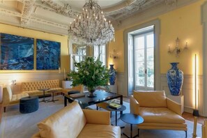 A luxurious room with a chandelier, a sofa, a coffee table, and a vase. - Verride Palácio Santa Catarina (Lisbon)