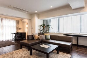 Un salon moderne avec un canapé, une table basse et de grandes fenêtres.