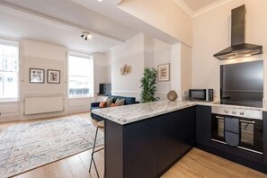 A modern kitchen with a large island, built-in oven, and microwave. - Host & Stay Seel St Townhouse Apt II (Liverpool)