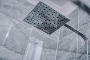 A showerhead with a curved handle, set against a tiled wall. - Host & Stay Seel St Townhouse Apt II (Liverpool)