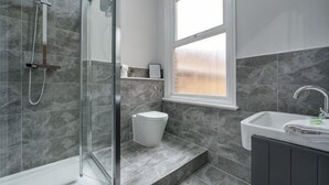 A bathroom with a glass shower enclosure, a toilet, a sink, and a window. - Host & Stay Seel St Townhouse Apt II (Liverpool)