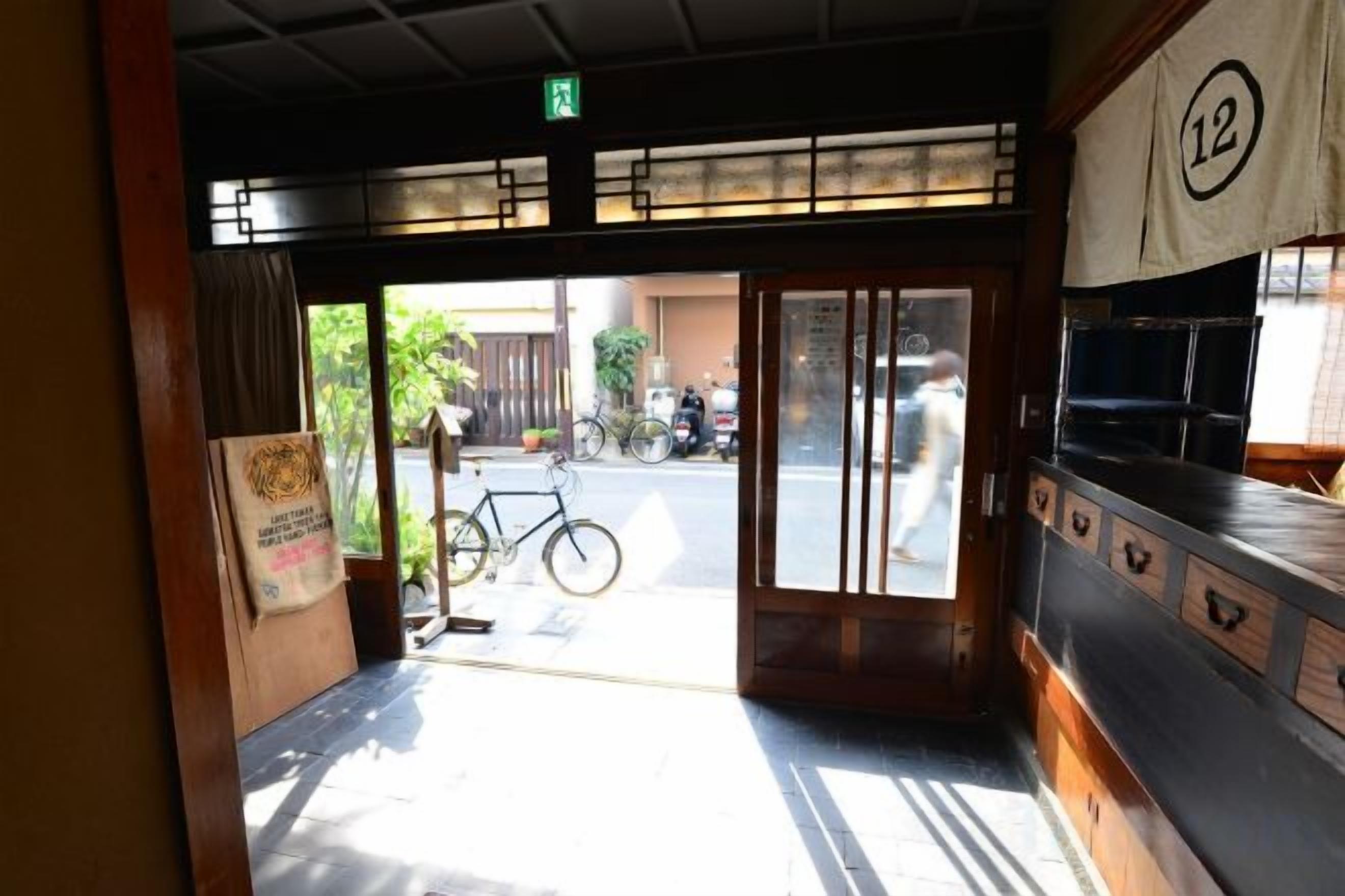 A doorway leading to a street with a bicycle parked outside.