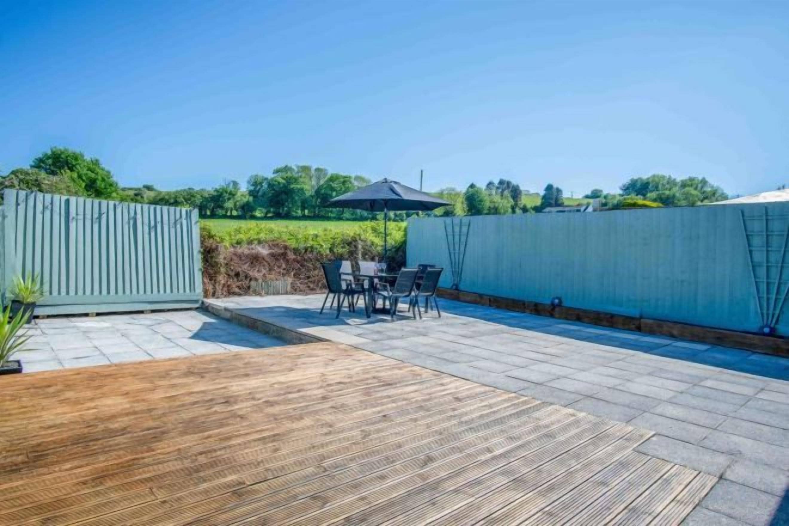 A patio with a wooden deck and a table with chairs.