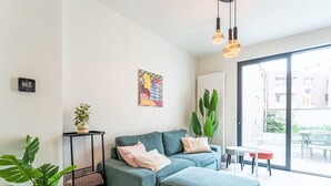 Un salon moderne avec un canapé d’angle, une petite table et une plante en pot.