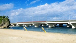 A bridge over water with a beach in the foreground. - Guest House Matsuyama (Naha)