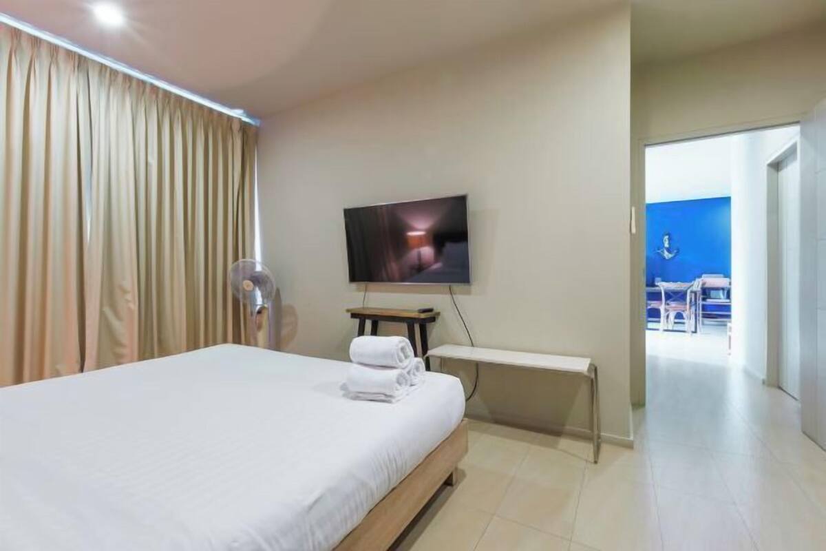 Une chambre d’hôtel avec un lit, une télévision, un bureau et une vue sur l’extérieur.