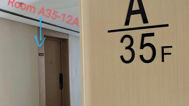 Un cartel de número de habitación de hotel que muestra 'Room A35-12A' y una puerta con 'A/35F' indicando el número de la habitación.