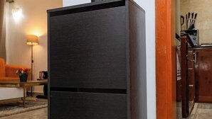 A modern kitchen with dark cabinetry, a countertop, and a visible stove. - T-Square Residence Makepe (Douala)