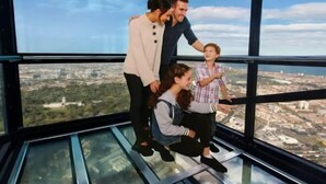 A group of people inside a high-rise building with large windows offering a city view. - A Cozy Apt with City Views Near Crown Casino (Southbank)