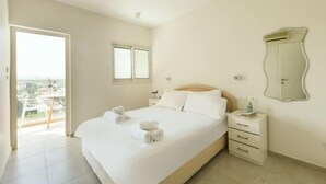 A hotel room with a bed, a bedside table, a mirror, and a balcony with a view. - Skyline 1BR Apartment with City and Sea View (Herzliya)