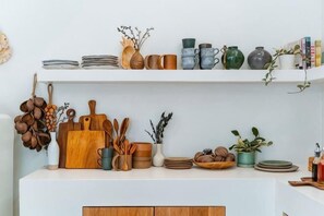 A kitchen with shelves holding various kitchenware and utensils. - Wynn resort (Bang Lamung)