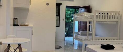 Una habitación con literas, una mesita pequeña y una silla.