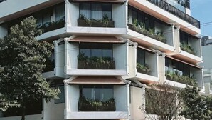 A multi-story building with balconies, windows, and a tree in the foreground. - The City Boutique Hotel (Bien Hoa)