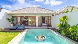 Una villa moderna con piscina, comedor y jardín bien cuidado.