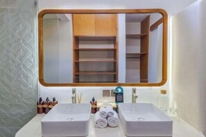 Ein Badezimmer mit zwei Waschbecken, einem Spiegel und einem Handtuchhalter.