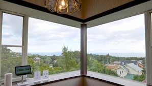 A room with large windows, a desk with a computer, and a hanging light fixture. - Private Villa Izu Omuro Kogen (Ito)