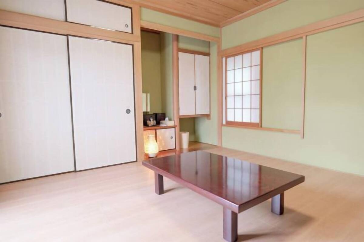 Een kamer met een houten tafel, schuifdeuren en een traditionele Japanse schuifdeur.