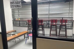 Une pièce avec une fenêtre, une table et des chaises.