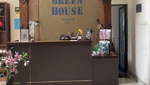 Um balcão de recepção com uma placa que diz "GREEN HOUSE EXCLUSIVE XOS".