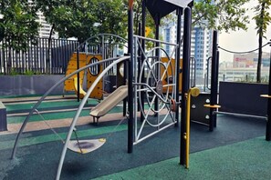 Un parque infantil con diversas estructuras de juego, incluyendo columpios y juegos de escalada.