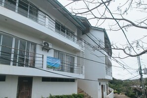 Un immeuble à plusieurs étages doté d’un balcon, d’un escalier et d’une banderole.