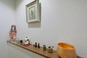 Un baño con encimera de madera, un cuadro enmarcado y varios artículos de aseo.
