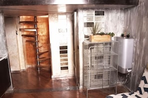 A room with a wooden staircase, a metal rack with plants, and a water heater. - The Model's Apartment - Urban Loft 56 Moscova - Fashion & Design Heart of Milano (Milan)